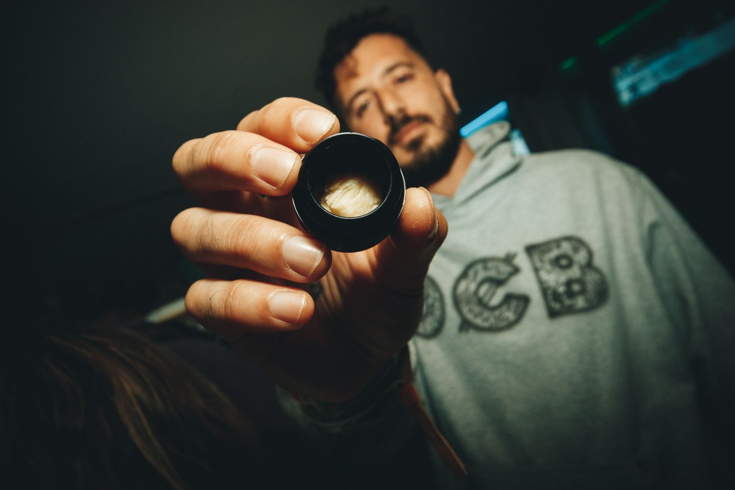 Man in an OCB sweatshirt holding out an open jar of cannabis concentrate at the Autoflower World Cup 2026