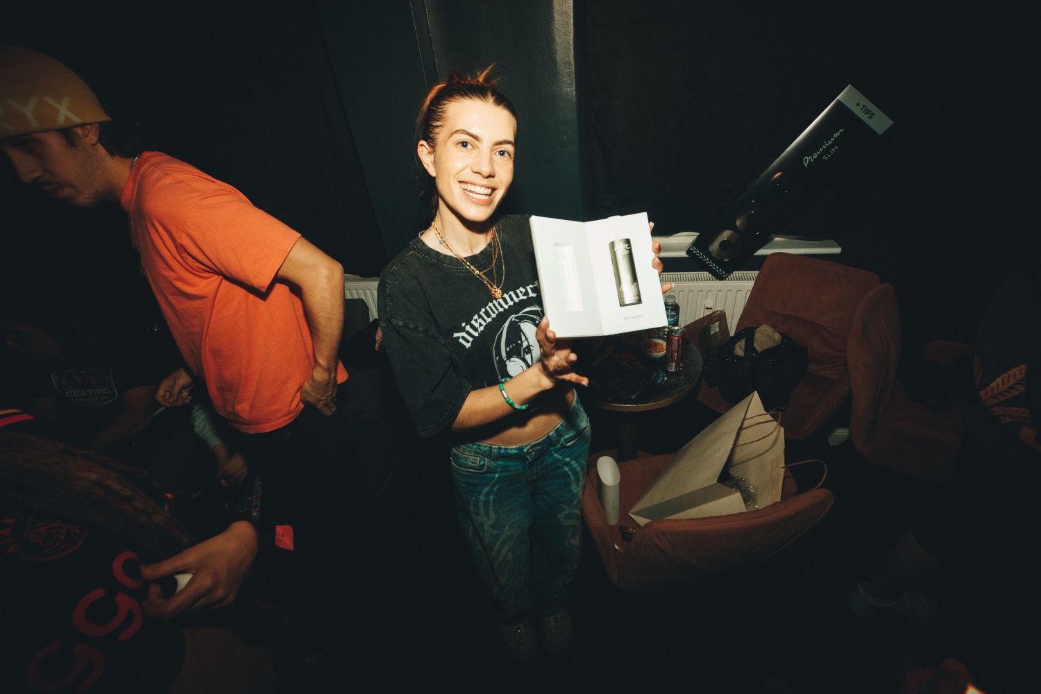 A guest smiling backstage at the Autoflower World Cup 2026 in Berlin, holding an AWC premium pre-roll gift box.
