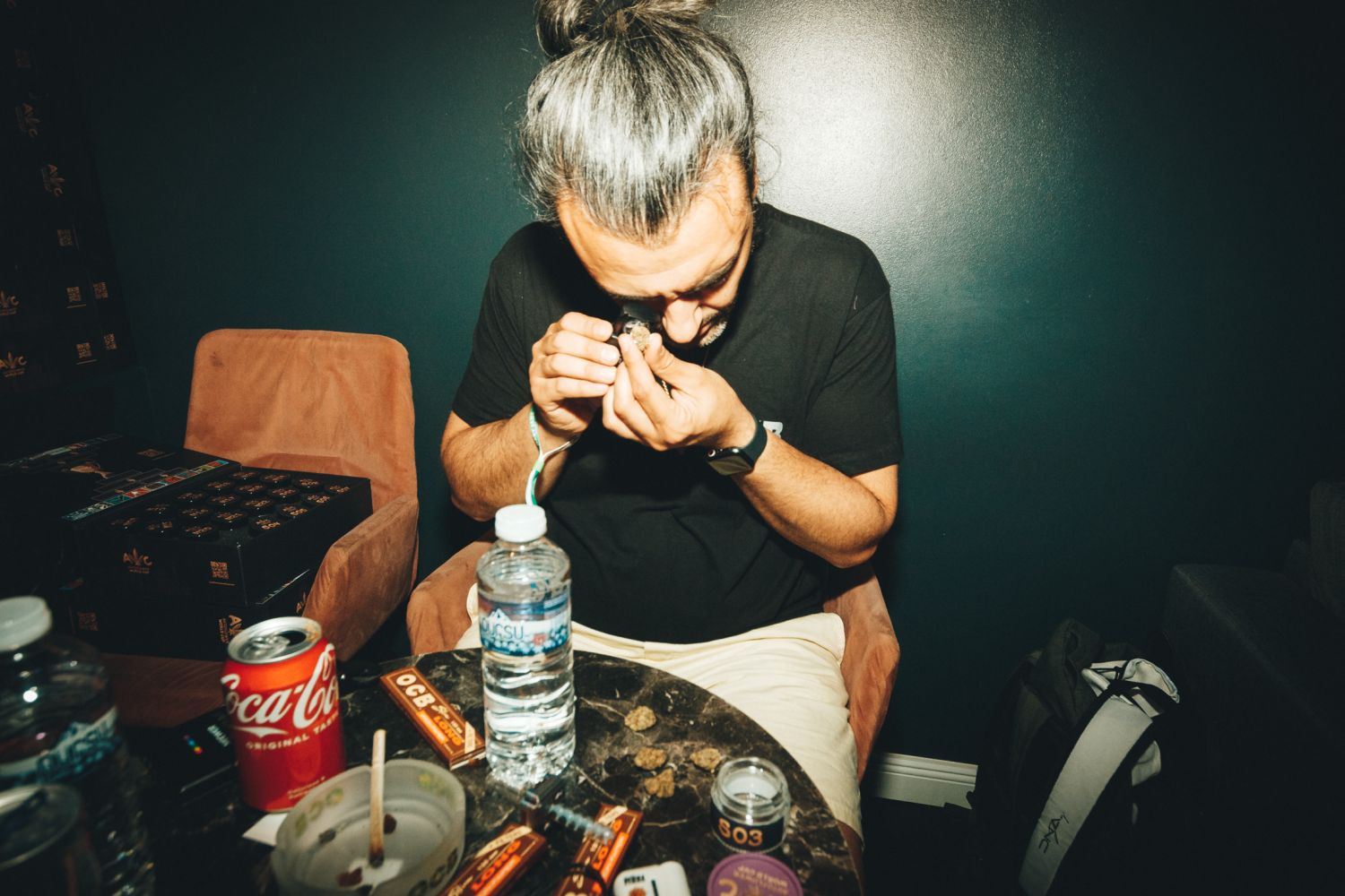 Autoflower World Cup judge examining a cannabis flower with a magnifying tool.